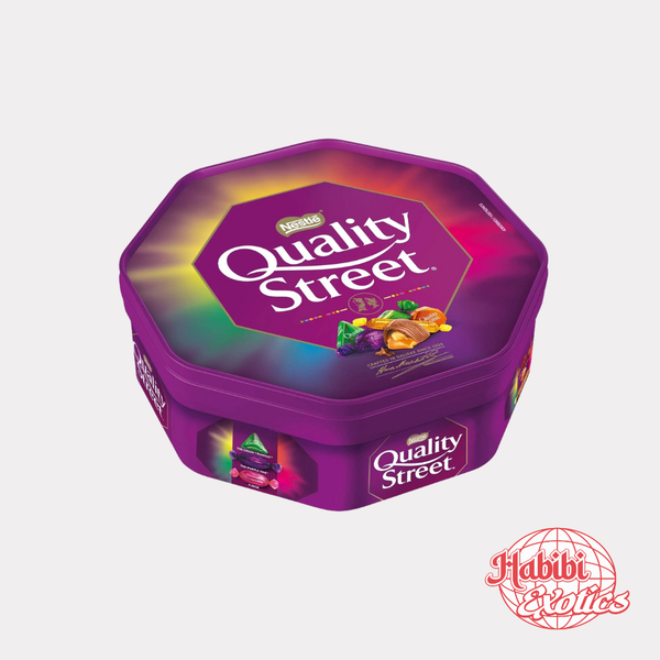 Purple Quality Street tin with colorful candy on a white background